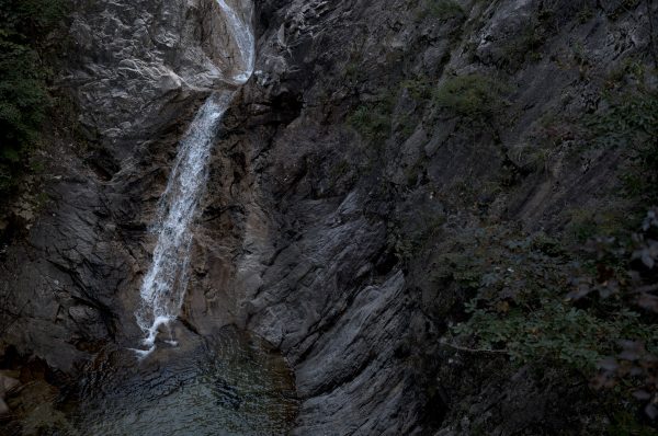 A beautiful waterfall cascading over rocky cliffs, surrounded by lush greenery. Nature 4K