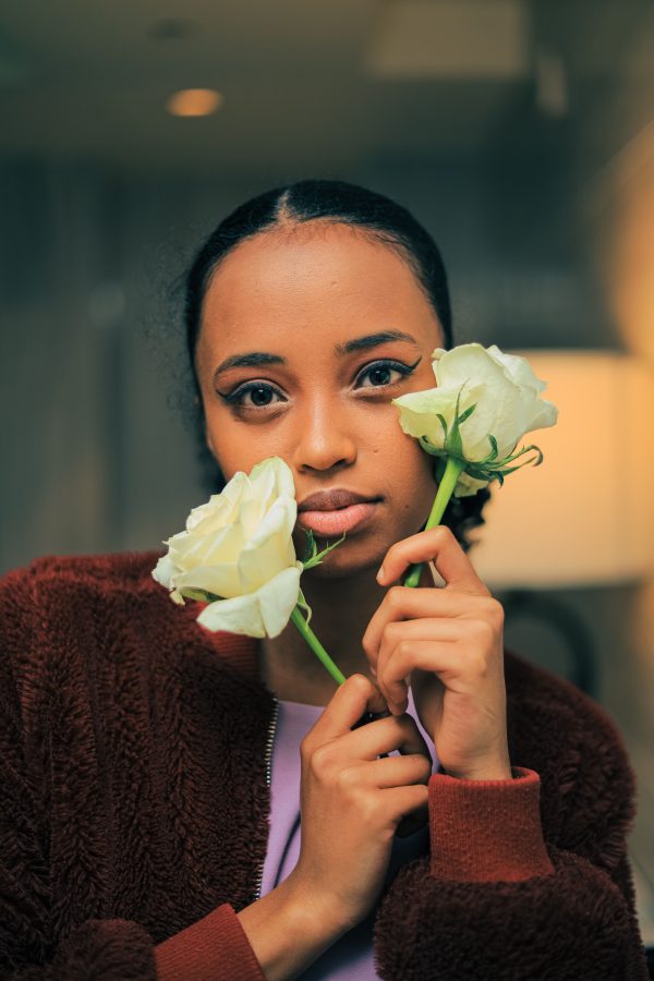 A beautiful woman holding two white roses in an intimate indoor setting. Mobile 4K