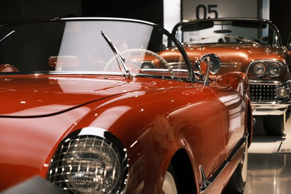 A beautifully preserved vintage red cabriolet showcased at a car exhibition indoors. Voitures 4K