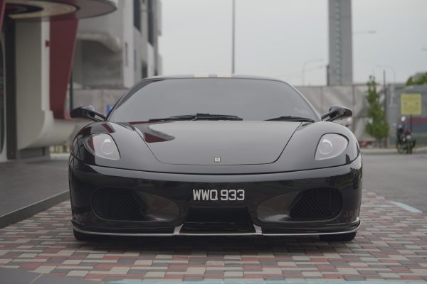 A black luxury sports car parked on a city street, showcasing its sleek design and elegance. Voitures 4K