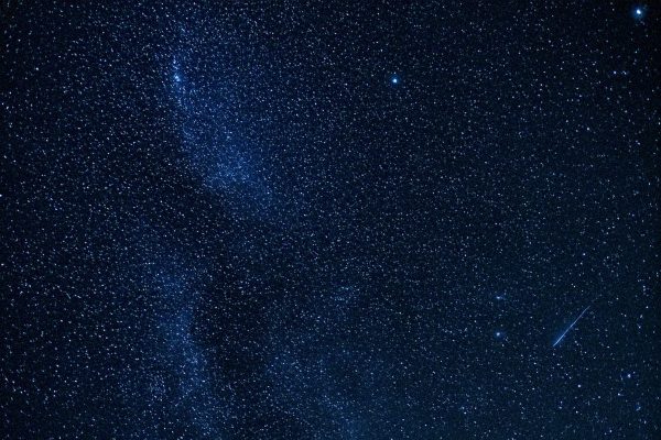 A breathtaking night sky filled with countless stars and a bright shooting star crossing the view. Espace 4K