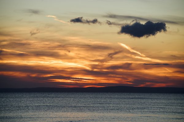 A breathtaking sunset over the sea with dramatic clouds and vibrant colors. Nature 4K