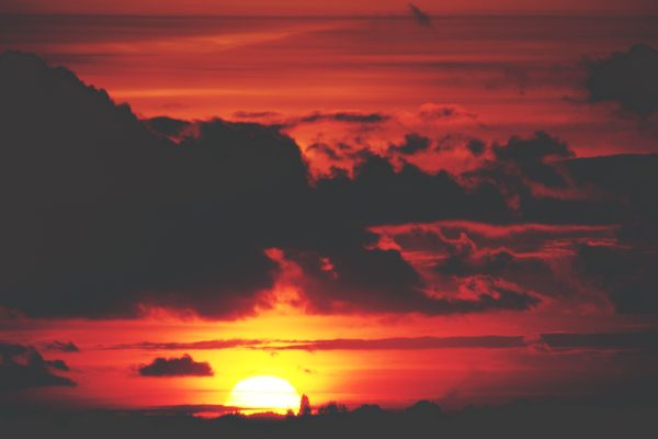 A breathtaking view of a dramatic red sunset with silhouetted clouds creating a moody atmosphere. Nature 4K