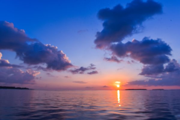 A breathtaking view of a tropical sunset with vibrant colors reflecting on the calm sea. Nature 4K