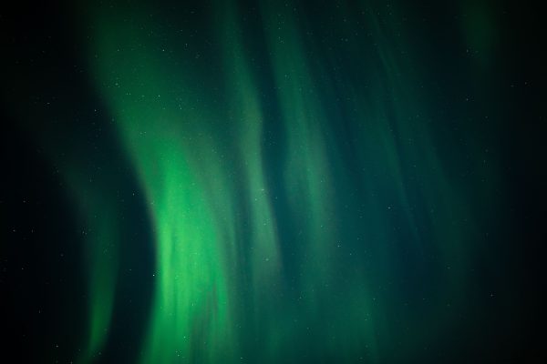 A breathtaking view of the aurora borealis illuminating the night sky with shimmering green lights. Espace 4K