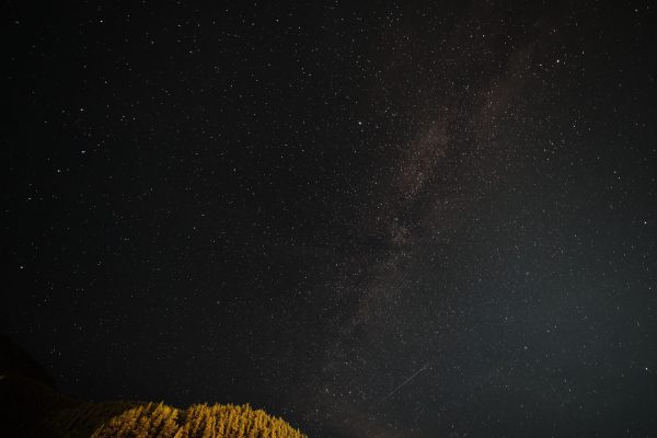 A breathtaking view of the Milky Way and stars over a forested landscape. Espace 4K