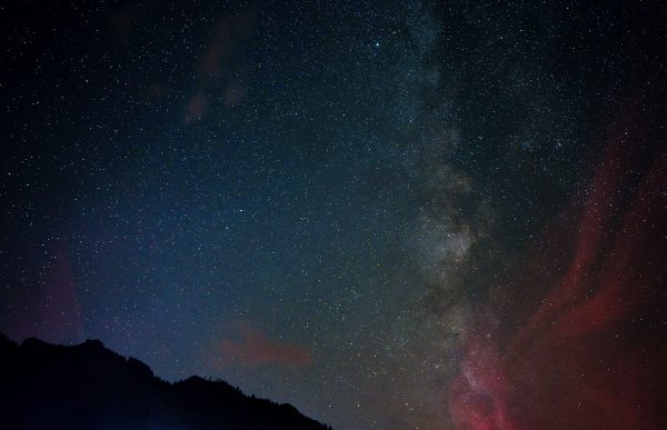 A breathtaking view of the Milky Way galaxy against a starry night sky, featuring a silhouetted landscape below. Espace 4K