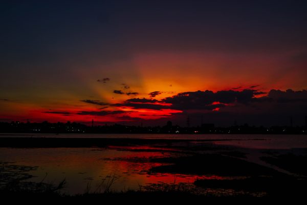 A breathtaking view of vibrant sunset colors casting reflections on a calm lake. Nature 4K
