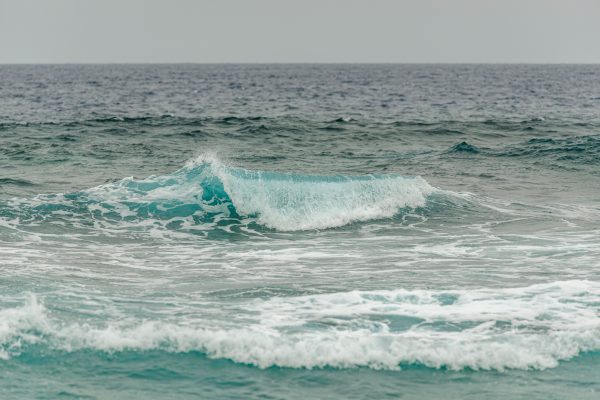 A calming ocean wave breaking on the sea surface under a cloudy sky, capturing the tranquility of nature. Nature 4K