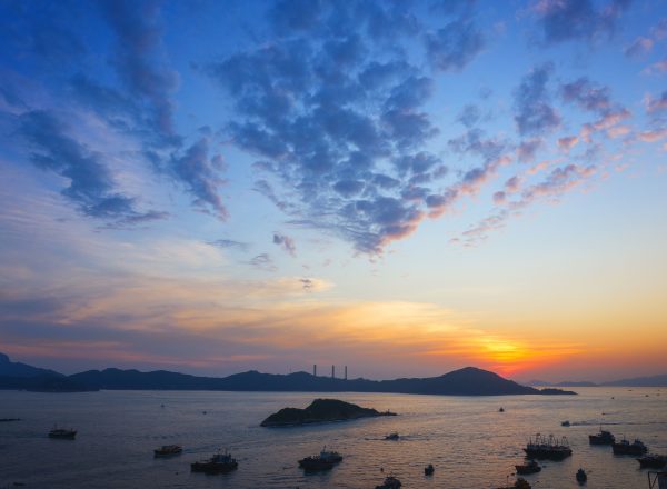 A captivating aerial view of a sunset over Hong Kong harbor with boats and islands. Nature 4K