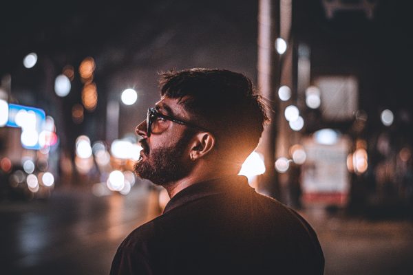 A captivating portrait of a man in Pune, India, with vibrant city lights at night. Voitures 4K