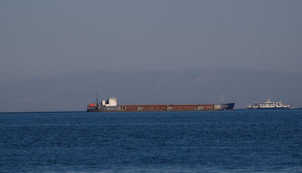 A cargo ship and ferry sailing near İzmir, Türkiye with distant mountains. Nature 4K