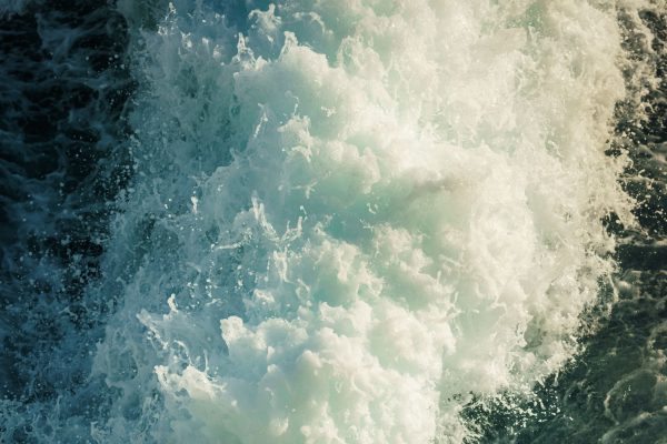 A close-up view capturing the vibrant energy and motion of ocean waves crashing against the shore. Nature 4K