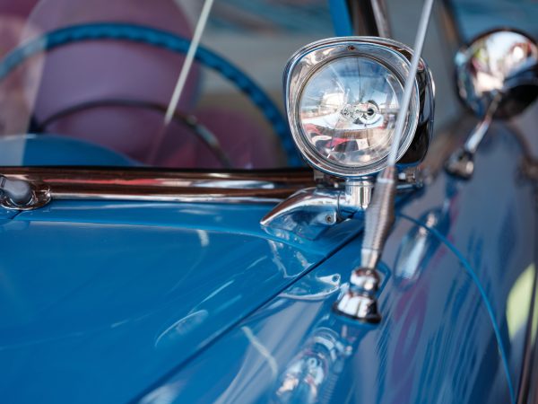 A detailed view of a vintage car's chrome headlamp and blue painted surface, capturing its retro design. Voitures 4K