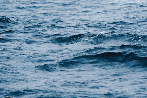 A detailed view of vibrant blue ocean waves creating an abstract aquatic texture, ideal for backgrounds. Nature 4K