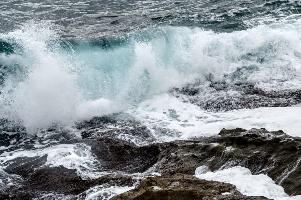 A dynamic capture of a powerful ocean wave crashing onto a rocky shore in Menton, France. Nature 4K