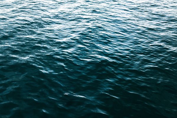 A dynamic capture of ocean water showing vivid textures and rich blue hues under daylight. Nature 4K