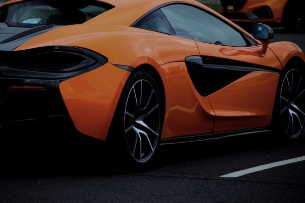 A dynamic shot of an orange sports car on a road in England, United Kingdom. Voitures 4K