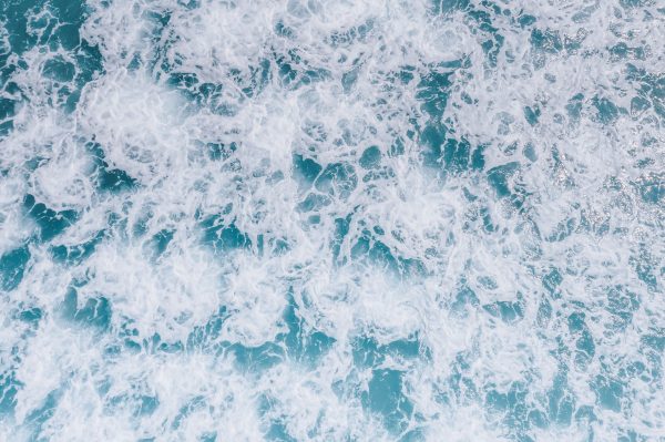 A dynamic top view of ocean waves and sea foam demonstrating nature's power and beauty. Nature 4K