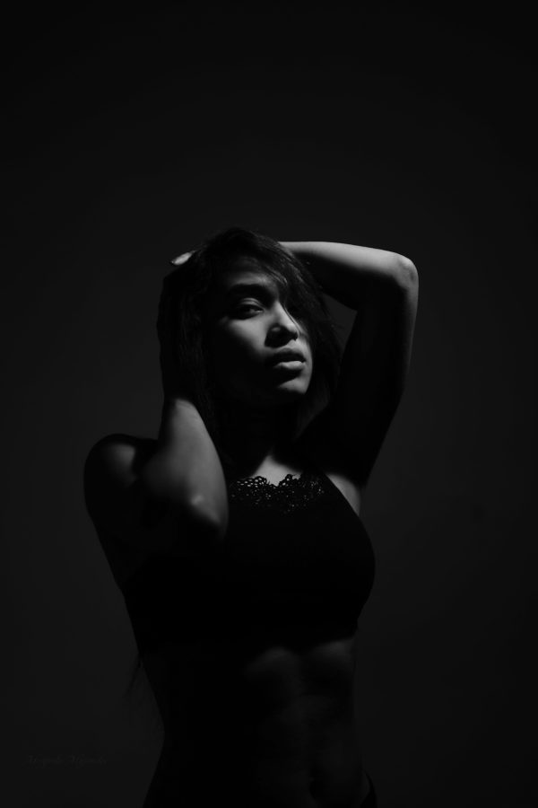 A grayscale photo capturing the allure and mystery of a woman in a studio setting. Mobile 4K