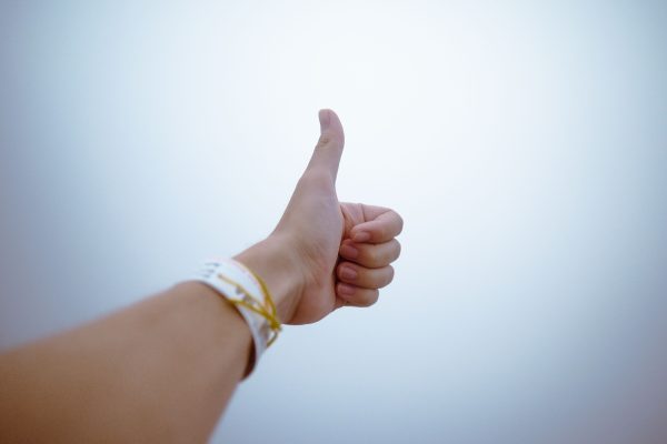 A hand giving a thumbs up gesture symbolizes approval and positivity. Minimaliste 4K
