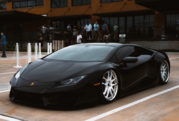 A luxurious black Lamborghini parked elegantly in a city setting, showcasing its sleek design. Voitures 4K