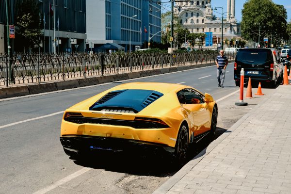 A luxurious yellow Lamborghini parked on a street in Istanbul, Turkey, next to a mosque. Voitures 4K