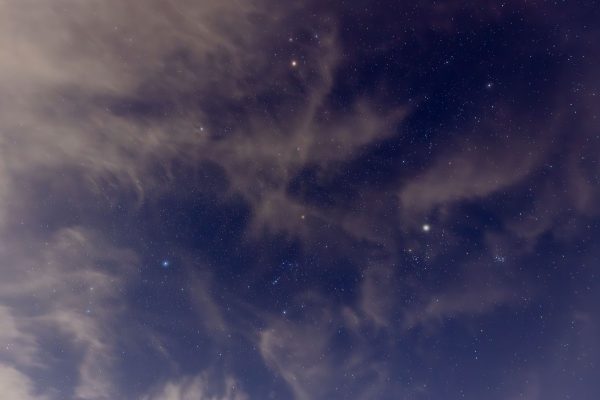 A mesmerizing view of a starry night sky with scattered clouds creating unique patterns. Espace 4K