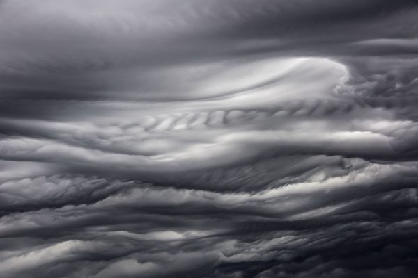 A mesmerizing view of dark, swirling clouds capturing the essence of a stormy atmosphere. Dark 4K
