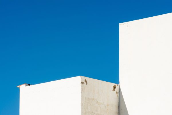 A minimalist composition of white buildings set against a vibrant blue sky, highlighting urban architecture. Minimaliste 4K