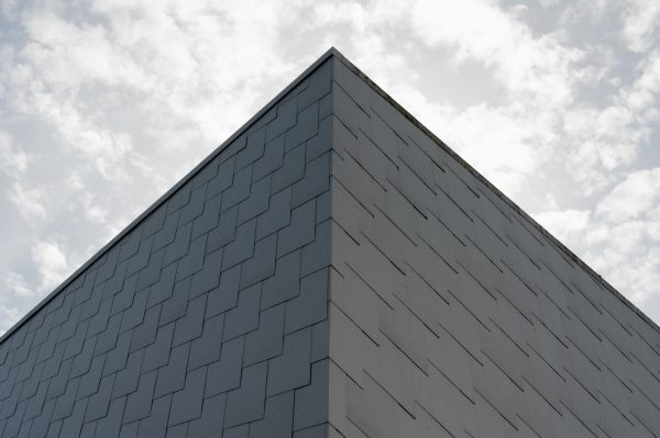 A minimalist corner view of a modern building in Porsgrunn, Norway, against a cloudy sky. Abstrait 4K
