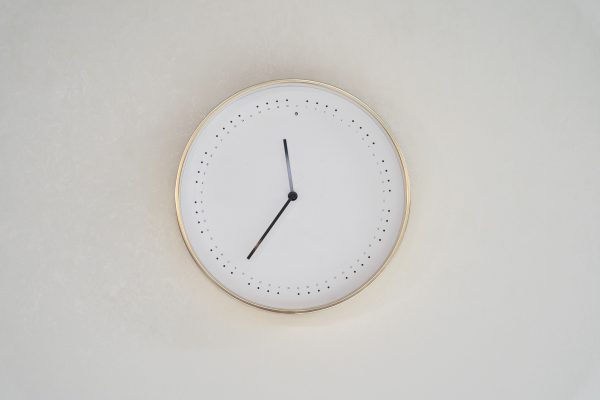 A minimalist design wall clock with a gold rim and no numbers on a neutral background. Minimaliste 4K