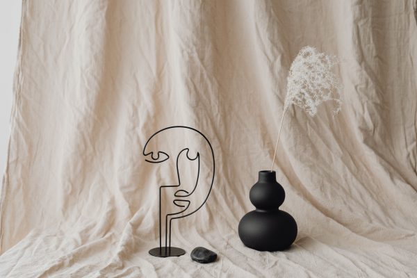 A minimalist still life features a sculpture, black vase, dry grass, and artistic decor. Minimaliste 4K