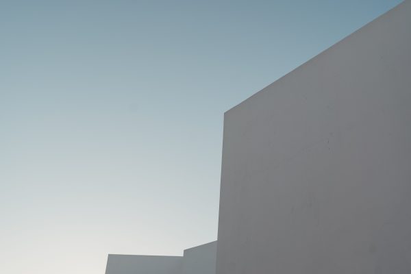A minimalist view of a modern building's facade under a clear blue sky. Minimaliste 4K