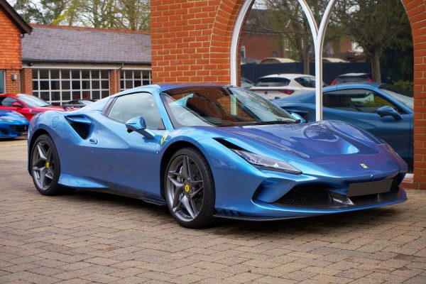 A modern blue sports car parked outdoors in an urban environment. Voitures 4K