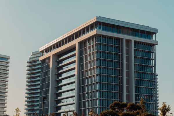 A modern highrise building with glass facade against a clear sky, showcasing urban architecture. Architecture 4K