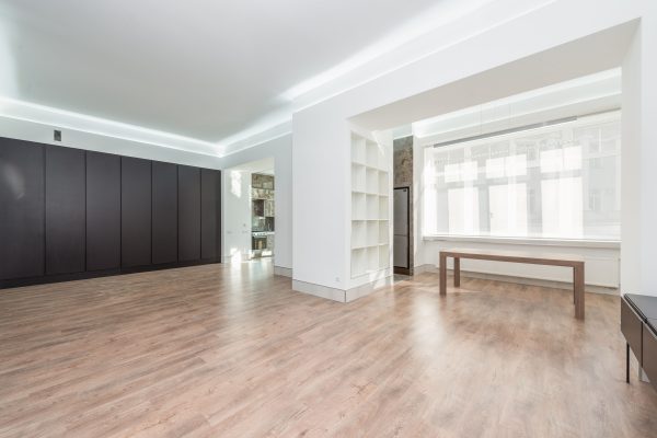 A modern minimalist room interior with hardwood flooring and sunlight streaming in through large windows. Minimaliste 4K