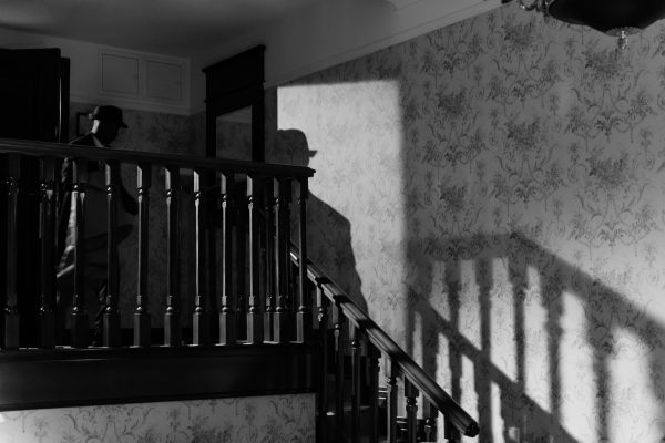 A mysterious noir scene with a detective's shadow on a vintage staircase. Dark 4K