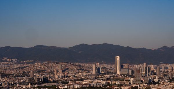 A panoramic view of İzmir city skyline with distant hills under a clear blue sky. Architecture 4K