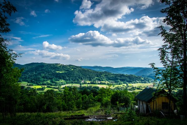 A picturesque countryside landscape featuring lush green hills under a bright blue sky. Nature 4K