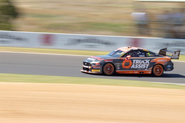 A racing car speeds around Mount Panorama track, showcasing dynamic motion and precision. Voitures 4K