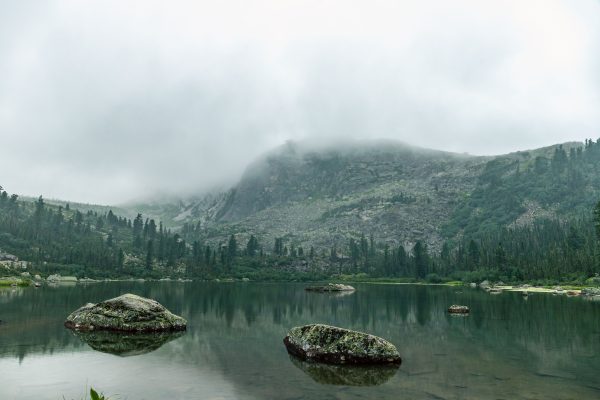 A serene lake surrounded by misty mountains and lush greenery, ideal for nature enthusiasts. Nature 4K