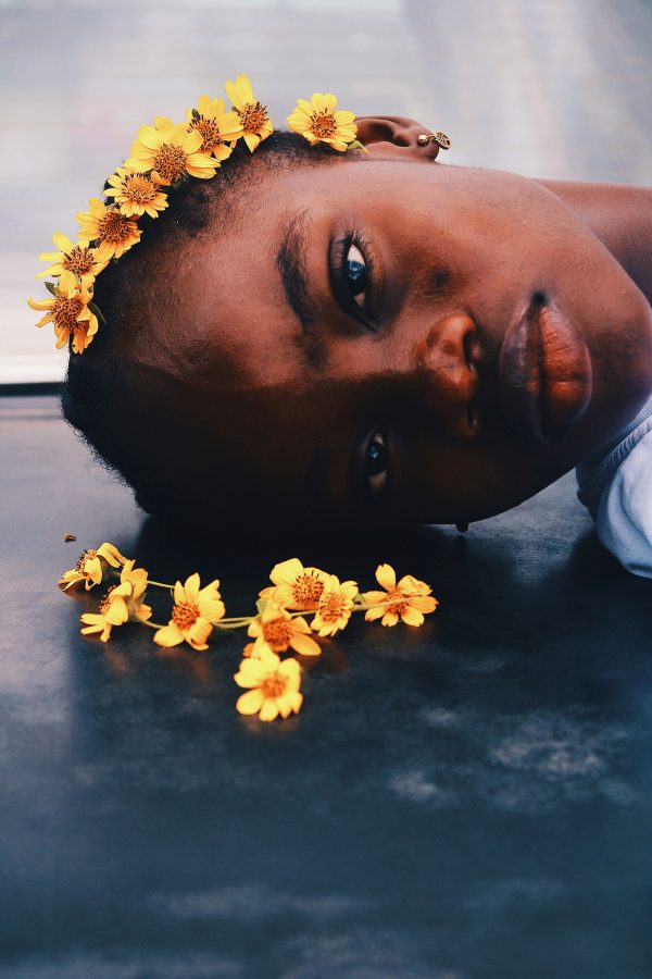 A serene portrait of a person lying with a yellow flower headband, exuding calm and beauty. Mobile 4K