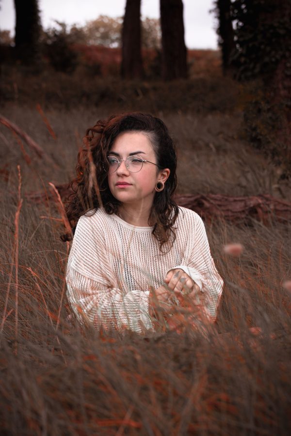A serene portrait of a woman in a cozy sweater within the autumn forest of Bretagne, France. Mobile 4K