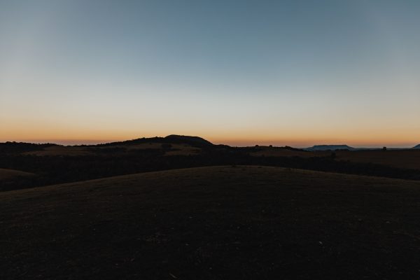 A serene view of a rural landscape at sunset with rolling hills silhouetted against the evening sky. Nature 4K