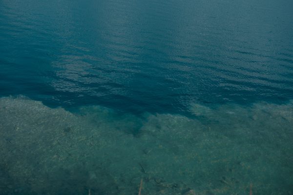 A serene view of blue ocean water with visible underwater textures and gentle surface ripples. Nature 4K