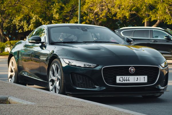 A sleek black Jaguar car parked outdoors in Rabat, Morocco, under the sunny sky. Voitures 4K