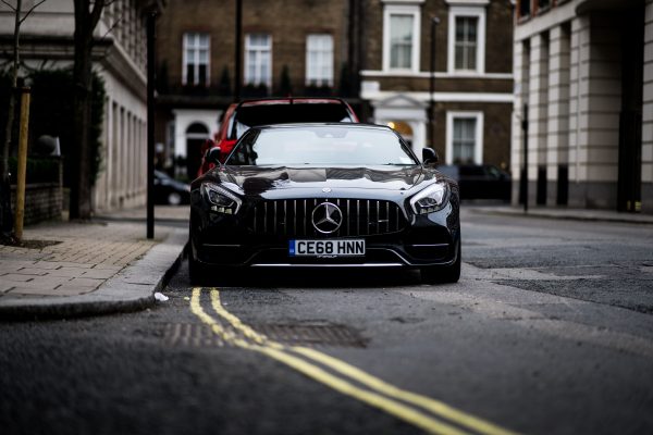 A sleek black Mercedes Benz parked on a London street, showcasing luxury and style. Voitures 4K