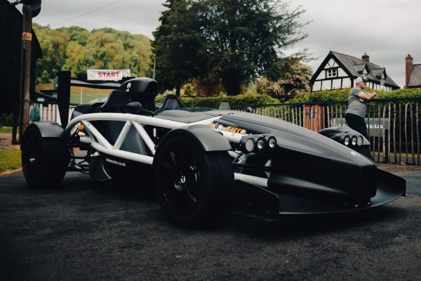 A sleek race car ready at the start line with a countryside backdrop. Voitures 4K