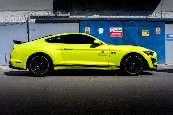 A sleek yellow sports car parked against an industrial backdrop in Türkiye. Voitures 4K
